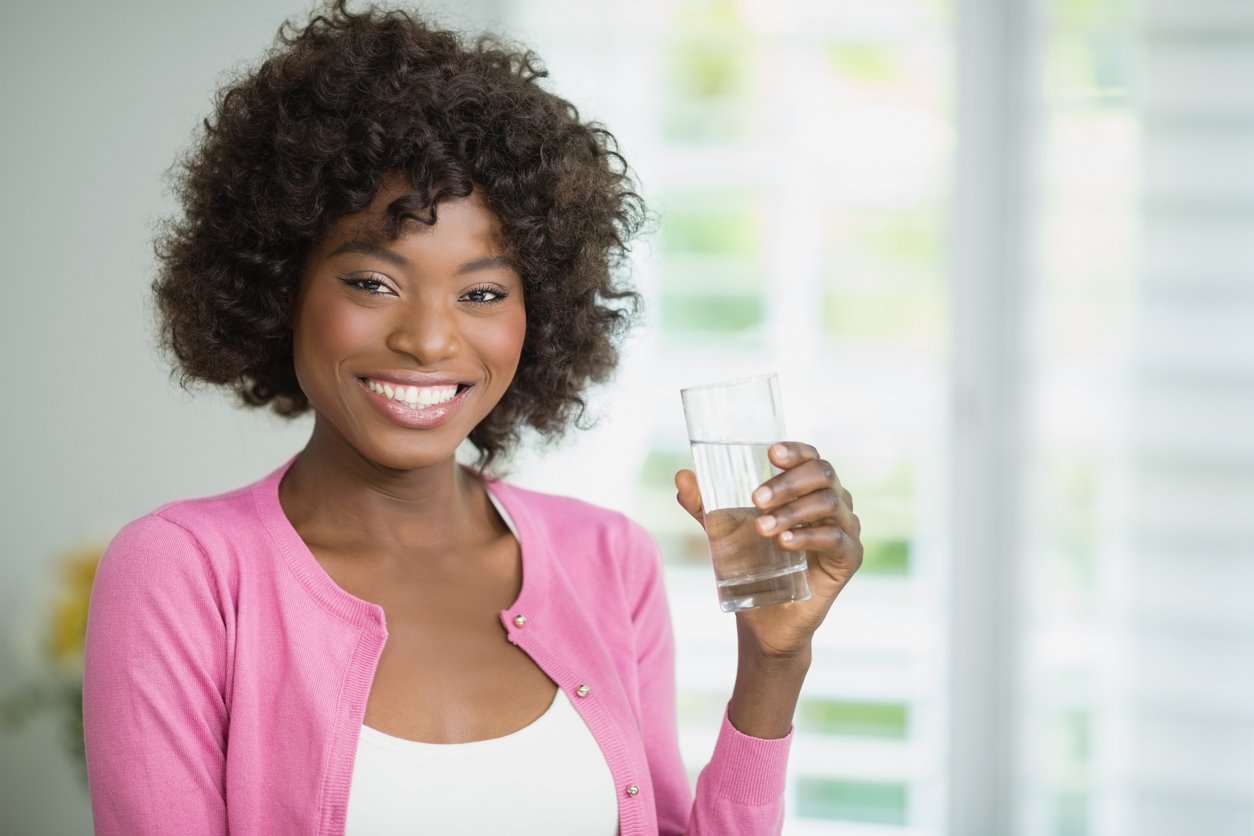 beautiful woman drinking water at home