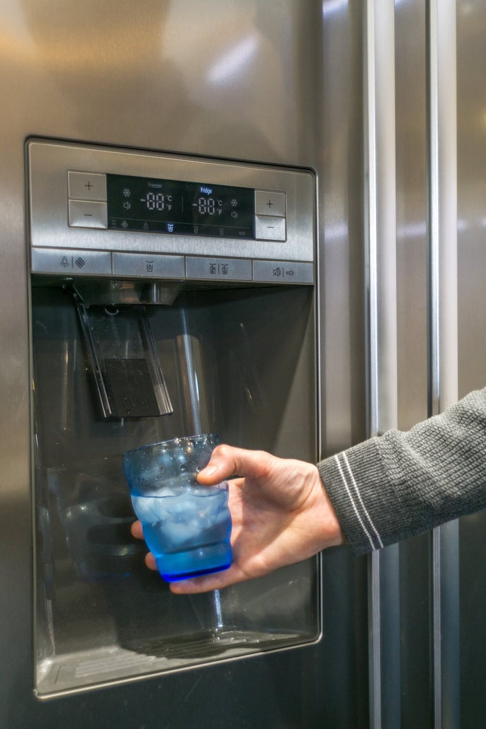 someone dispensing water from refrigerator