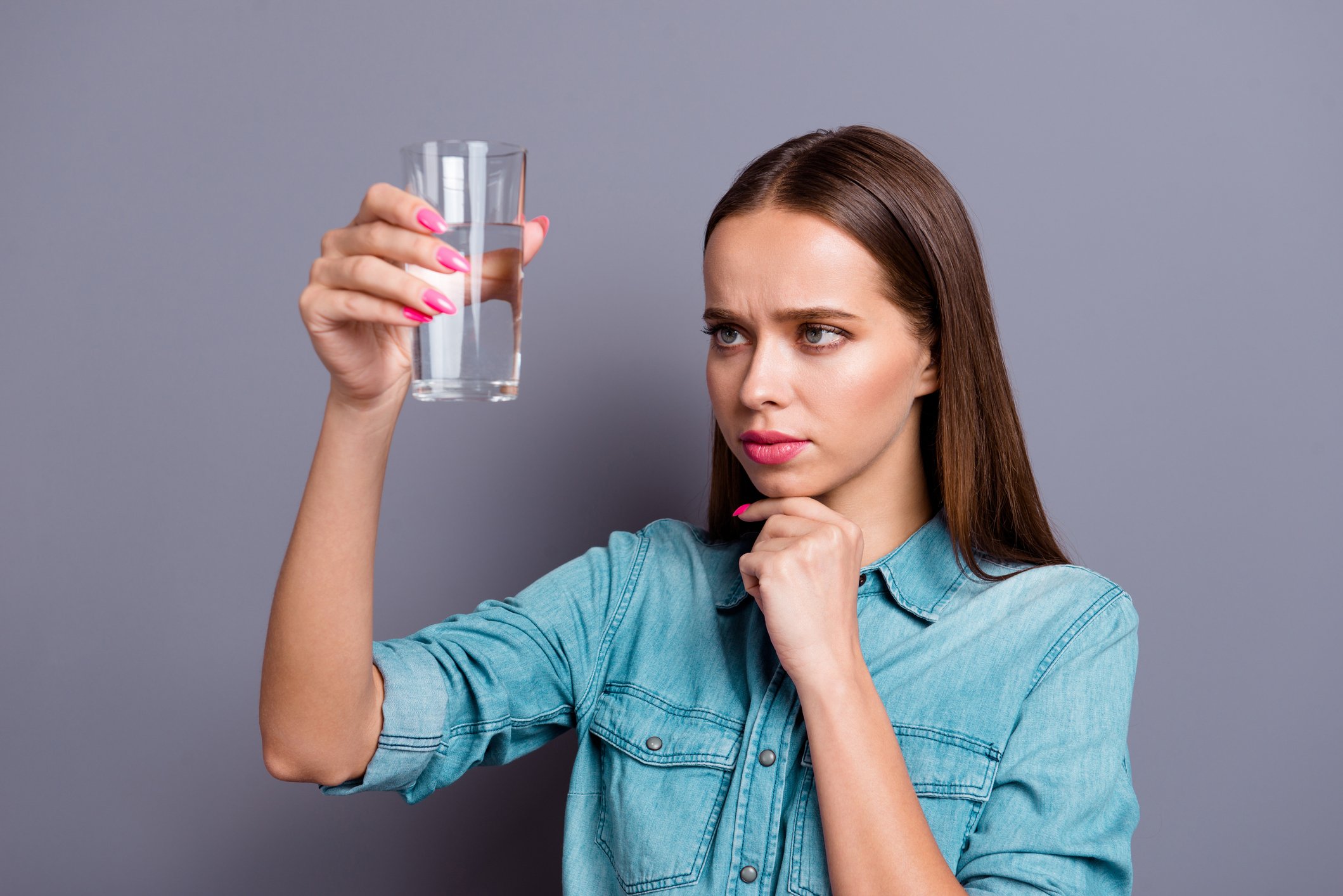 woman looking at a glass of water