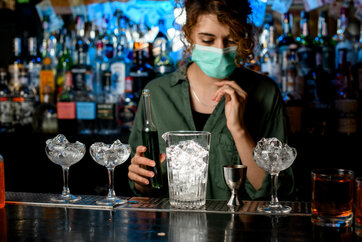woman bartender with ice in glasses