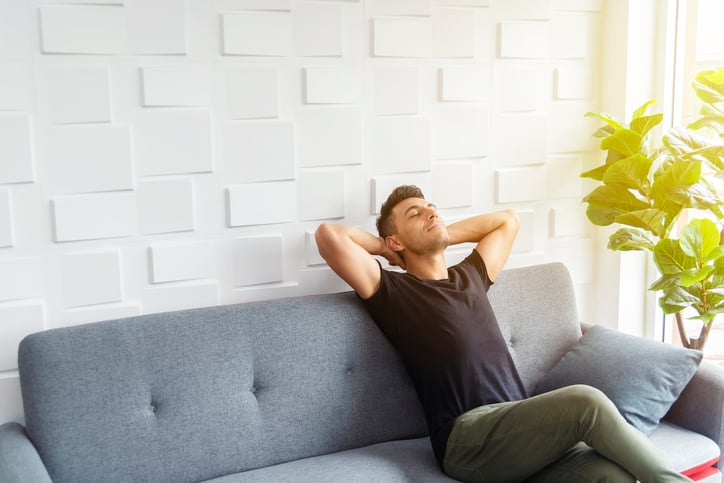man relaxing at home breathing in fresh, clean air