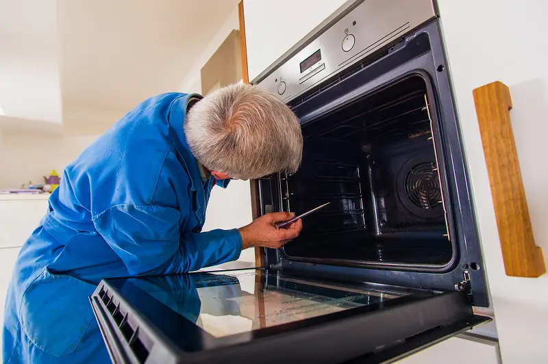 Technician inspecting an oven
