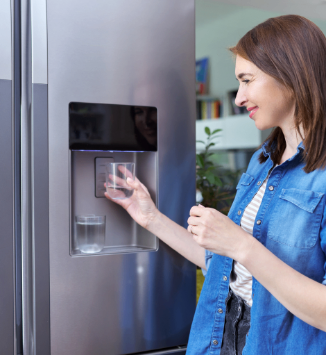 Woman using refrigerator water dispenser
